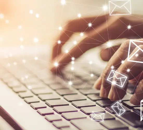 Hands typing on a keyboard with digital envelope icons, representing AI-assisted USPTO office action responses
