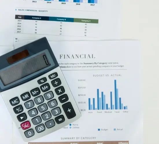 Calculator and printed financial charts, representing AI-powered IP spend and billing forecasting